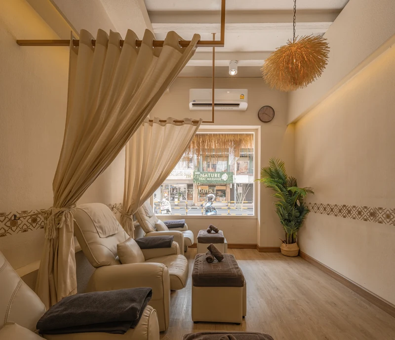 Warm-lit treatment room with a floor mattress and folded Thai massage clothes at ThaiThai Massage flagship on Siam Square Soi 6, a massage in Siam Bangkok